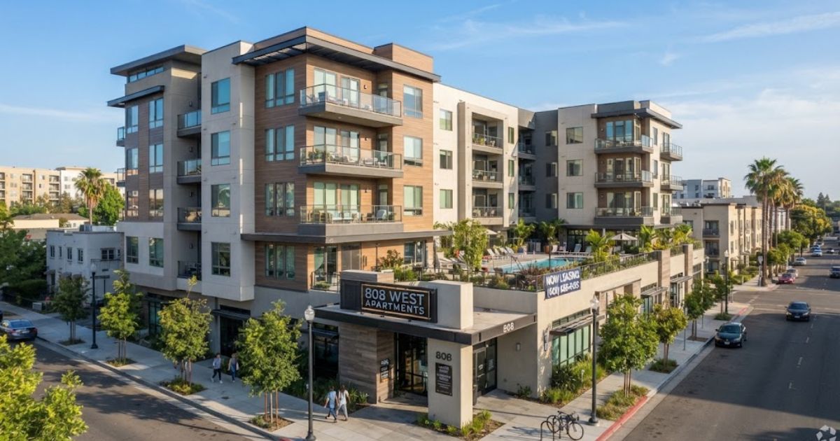 Exterior view of 808 West Apartments, a modern 6-story residential building located on a city street corner with prominent entrance signage, private balconies, landscaped sidewalks, and an outdoor courtyard pool area.