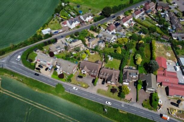 Aerial drone shot of a rural UK village with residential properties and surrounding land for property development advice UK