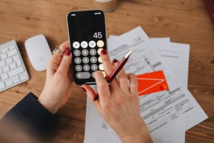 Person calculating tax figures on smartphone for Rachel Reeves property tax updates