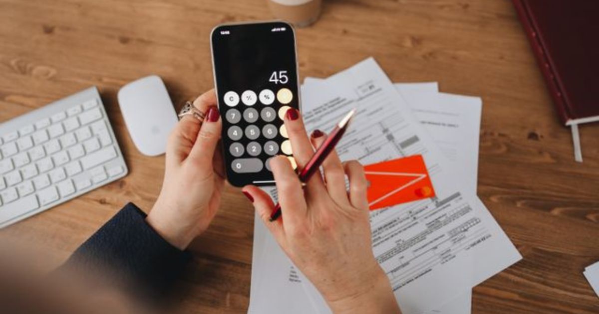 Person calculating tax figures on smartphone for Rachel Reeves property tax updates