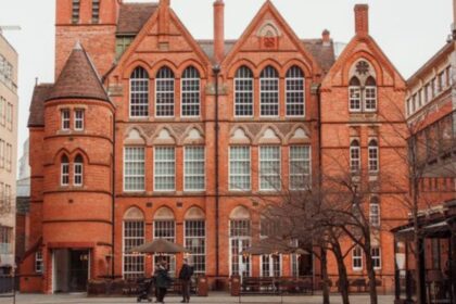 Birmingham Magistrates Court ki laal eint wali purani imaarat ki tasveer, jis ke saamne ek café patio aur kuch log dikhai de rahe hain.