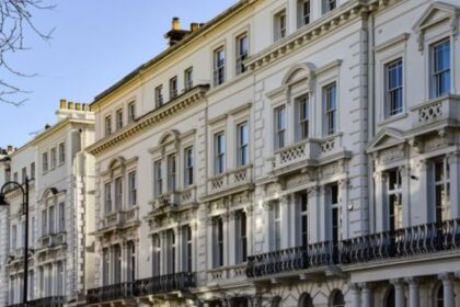 London mein purani Georgian tarze-tameer ki safaid imarat ki qatar, jis mein iron railings aur baramday nazar aa rahay hain.