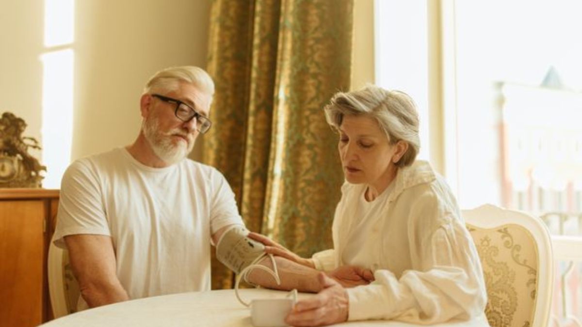 Nursing assistive personnel helping a patient walk in a hospital corridor