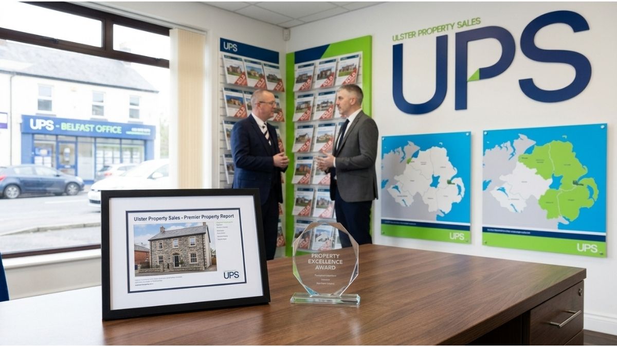A framed Ulster Property Sales (UPS) listing document and award on a wooden desk in a professional Northern Ireland office.