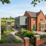 Modernized luxury detached house for sale in Wolverhampton featuring a spacious driveway, contemporary extension, and lawn garden with a For Sale sign.
