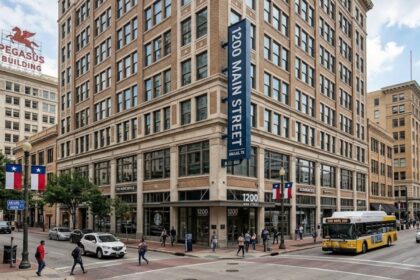 1200 Main Street Dallas historic brick building with pedestrians, city streets, and public transit.